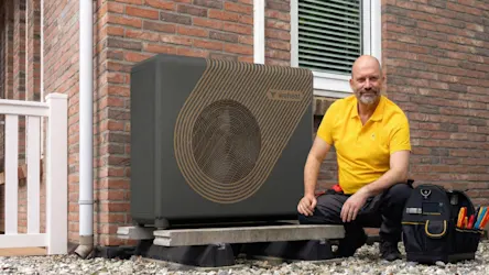 Monteur poseert naast warmtepomp