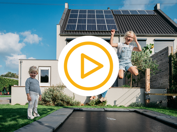 Foto van spelende kinderen in een zonnige tuin met zonnepanelen op het dak van het huis op de achtergrond en een video play button