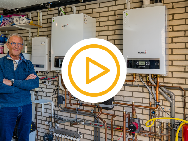 Klant van samangroep staat naast zijn nieuwe cv-ketel met video play button 