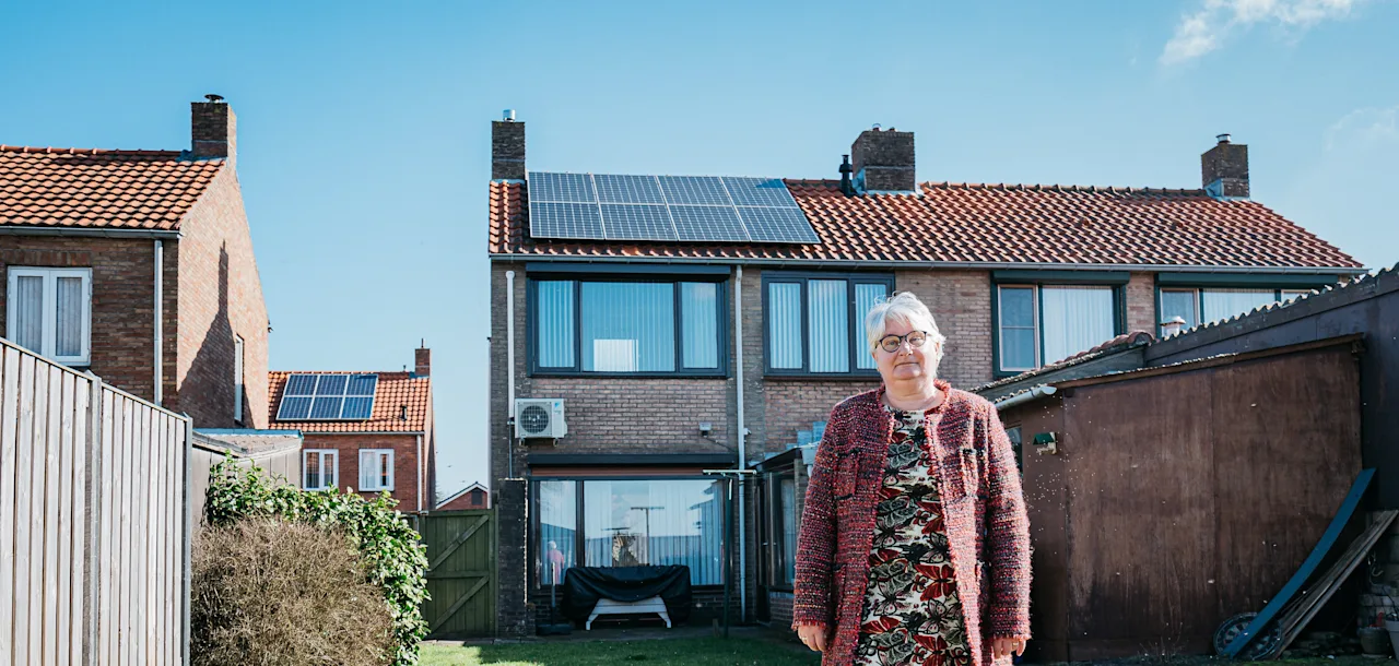 Tevreden klant poseert in tuin voor haar nieuwe zonnepanelen