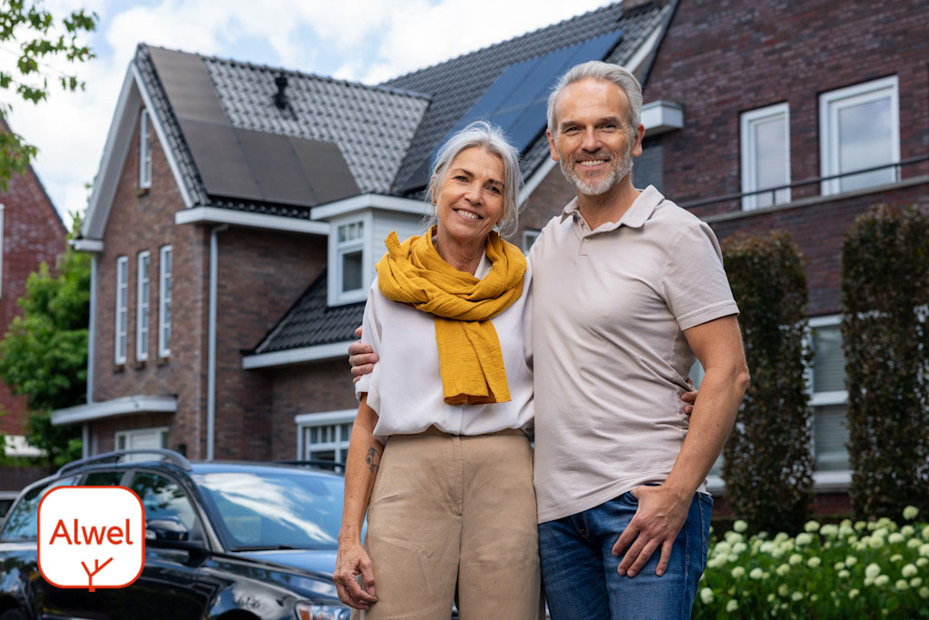 Afbeelding met 2 blije klanten met de nieuwste zonnepanelen op hun dak in samenwerking met alwel