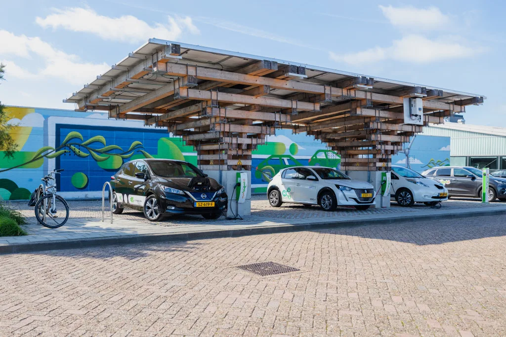 Een foto van een publieke laadpunt waarbij auto's opladen tegenover openbare laadtarieven
