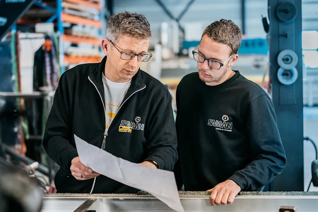 Monteurs kijken samen naar bouwtekening