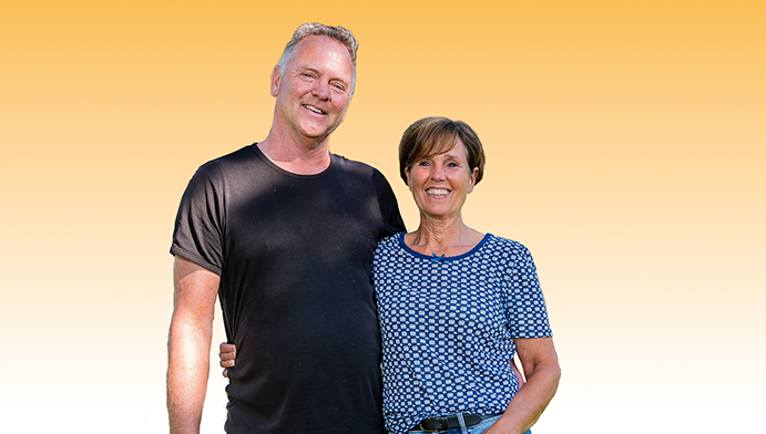 2 blije klanten van de saman groep die een een arm om elkaar heen slaan met een gele gradiënt op de achtergrond