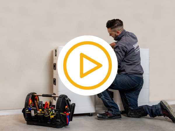 Saman monteur installeert 2 thuisbatterijen in een ruime omgeving en een video play button