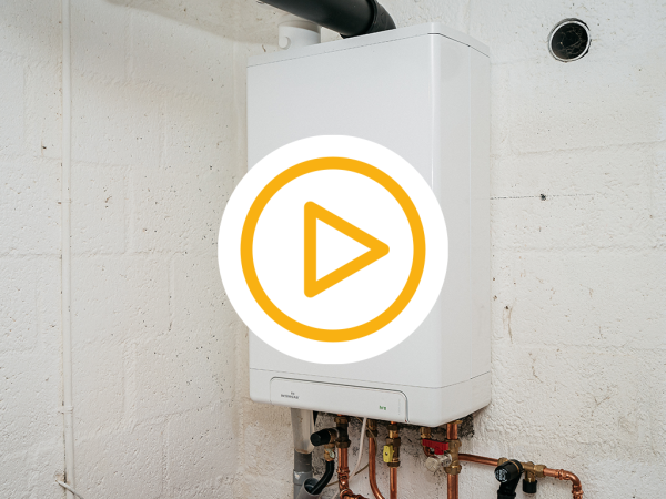 Geinstalleerde cv-ketel opgehangen aan de muur en een video play button