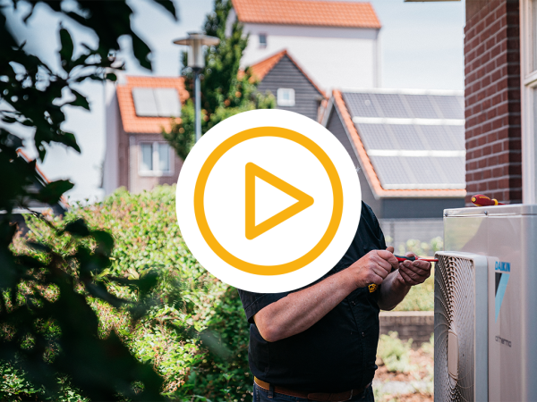 Saman monteur installeert buiten unit van een warmtepomp en een video play button