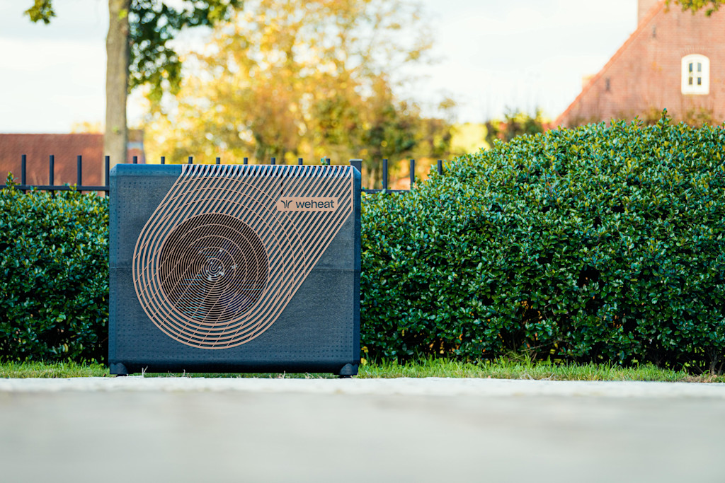 Weheat Sparrow warmtepomp in tuin vrijstaand voor een heg