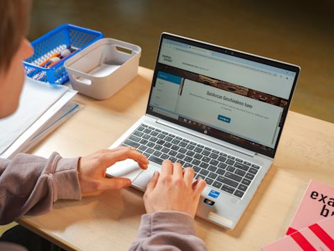 Leerling maakt quickscan geschiedenis op laptop met Examenbundel naast zich