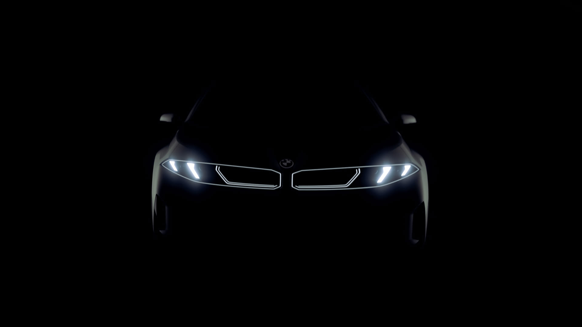 Front view of a BMW in darkness, with illuminated headlights and outlined kidney grille.