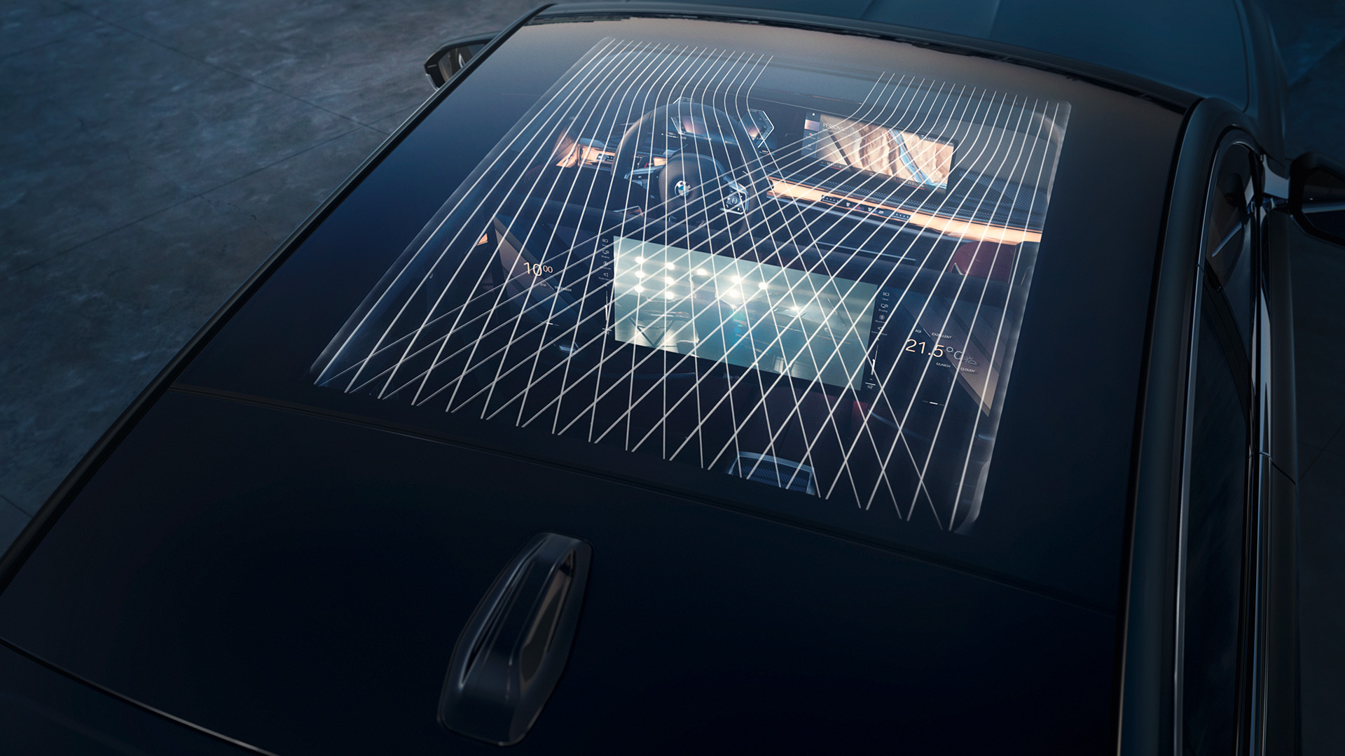 View through the sunroof of a car showing the interior dashboard, steering wheel and a large digital screen mounted behind the front seats, with reflections of a grid pattern on the glass.