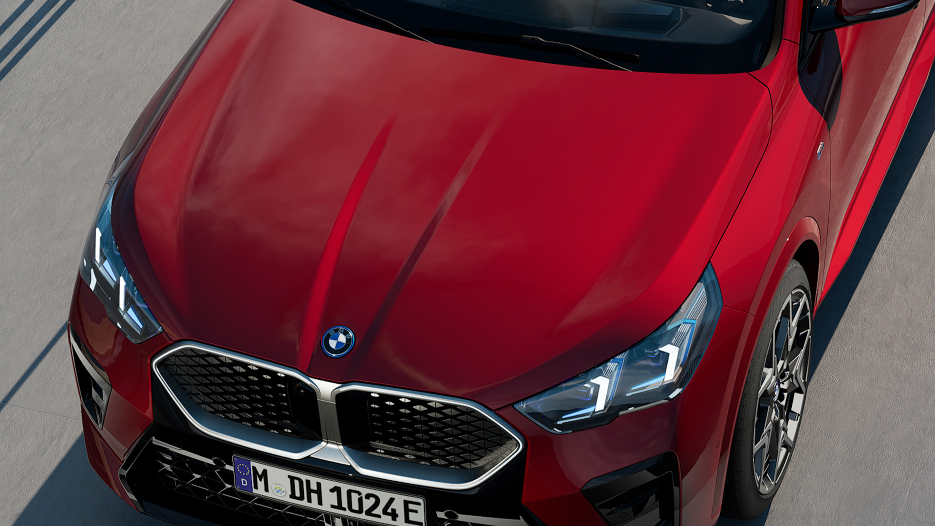 Top view of a red BMW car with a visible front grille and headlights.