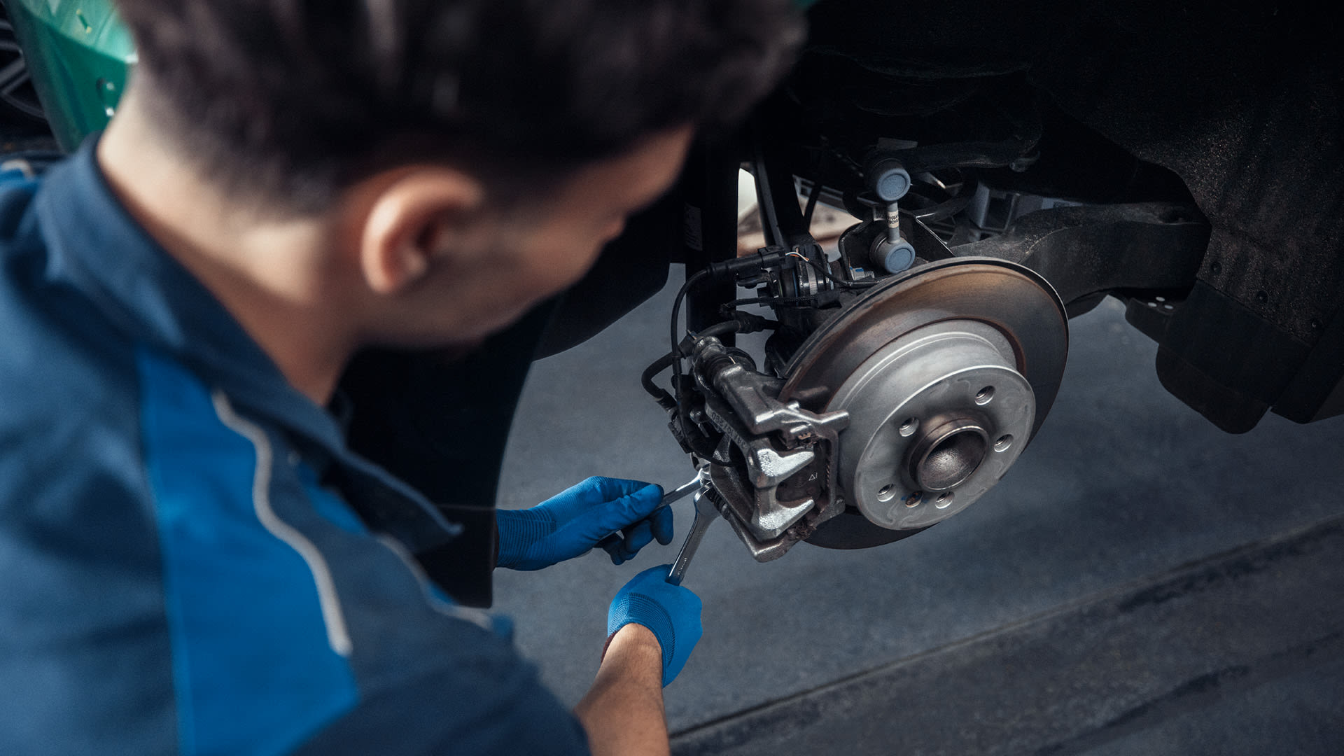 Service worker checking the breaks on a car