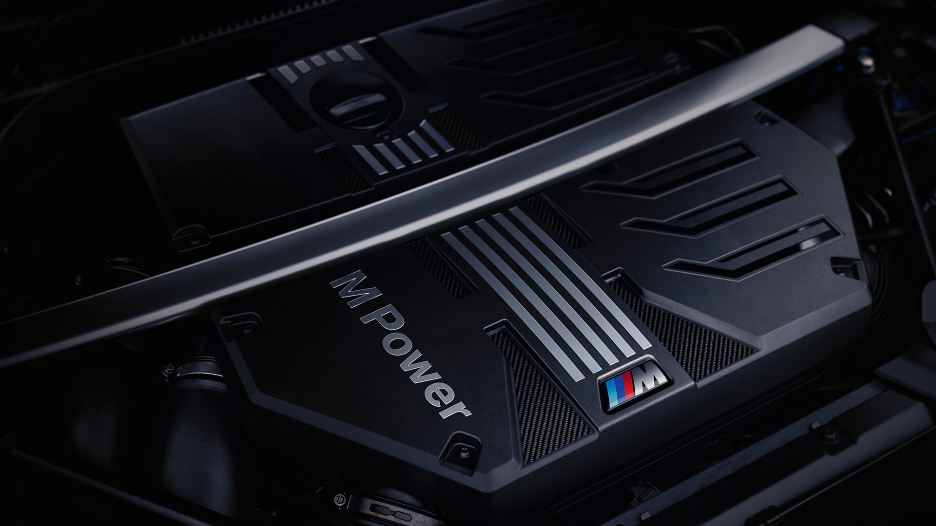 Close-up view of a BMW M Power engine with the M logo and a metallic strut bar across the top.