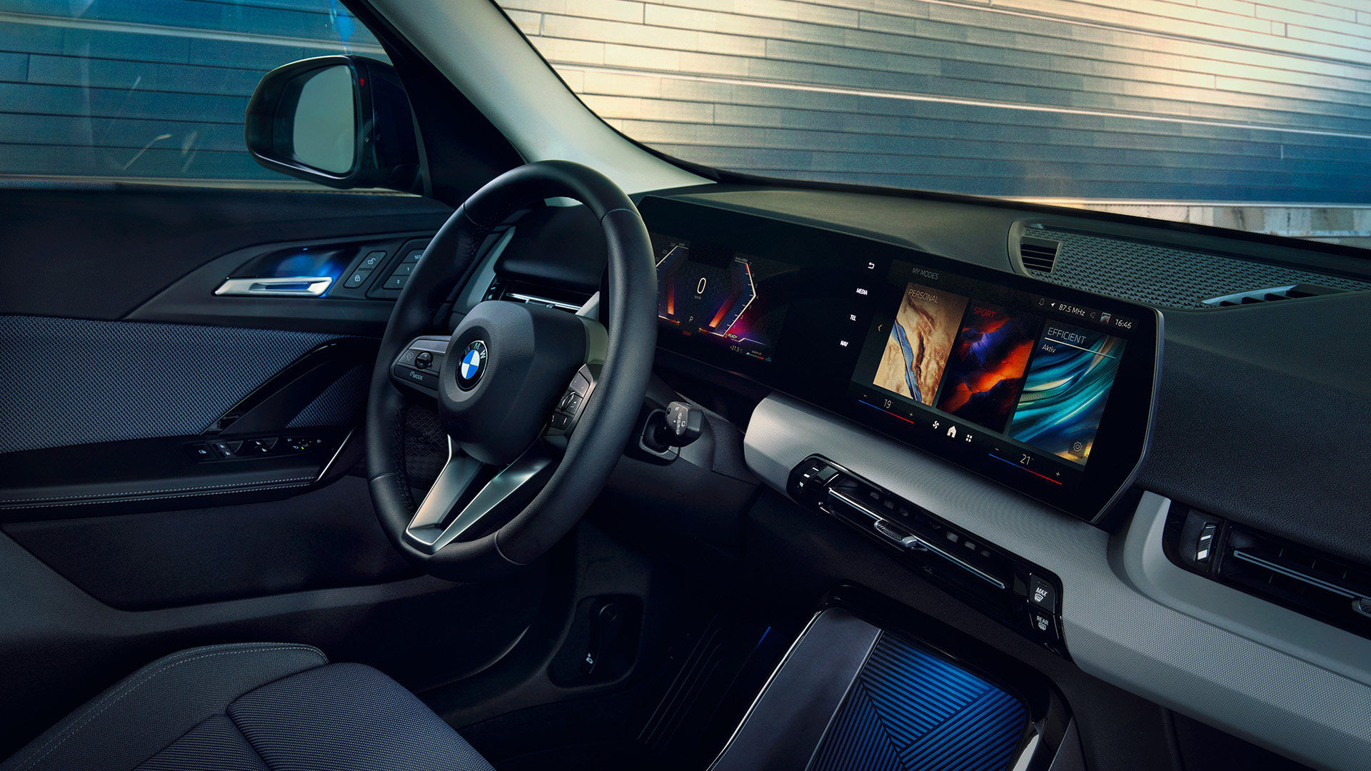 Interior view of a modern BMW car showcasing the steering wheel, dashboard, and multiple digital displays.