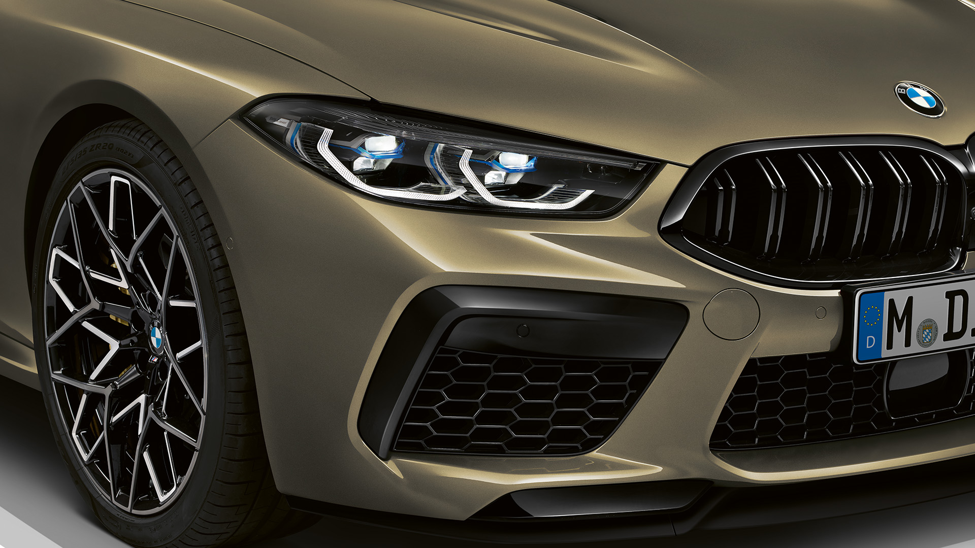 Front view of a metallic brown BMW car showing the right headlight and front grille.