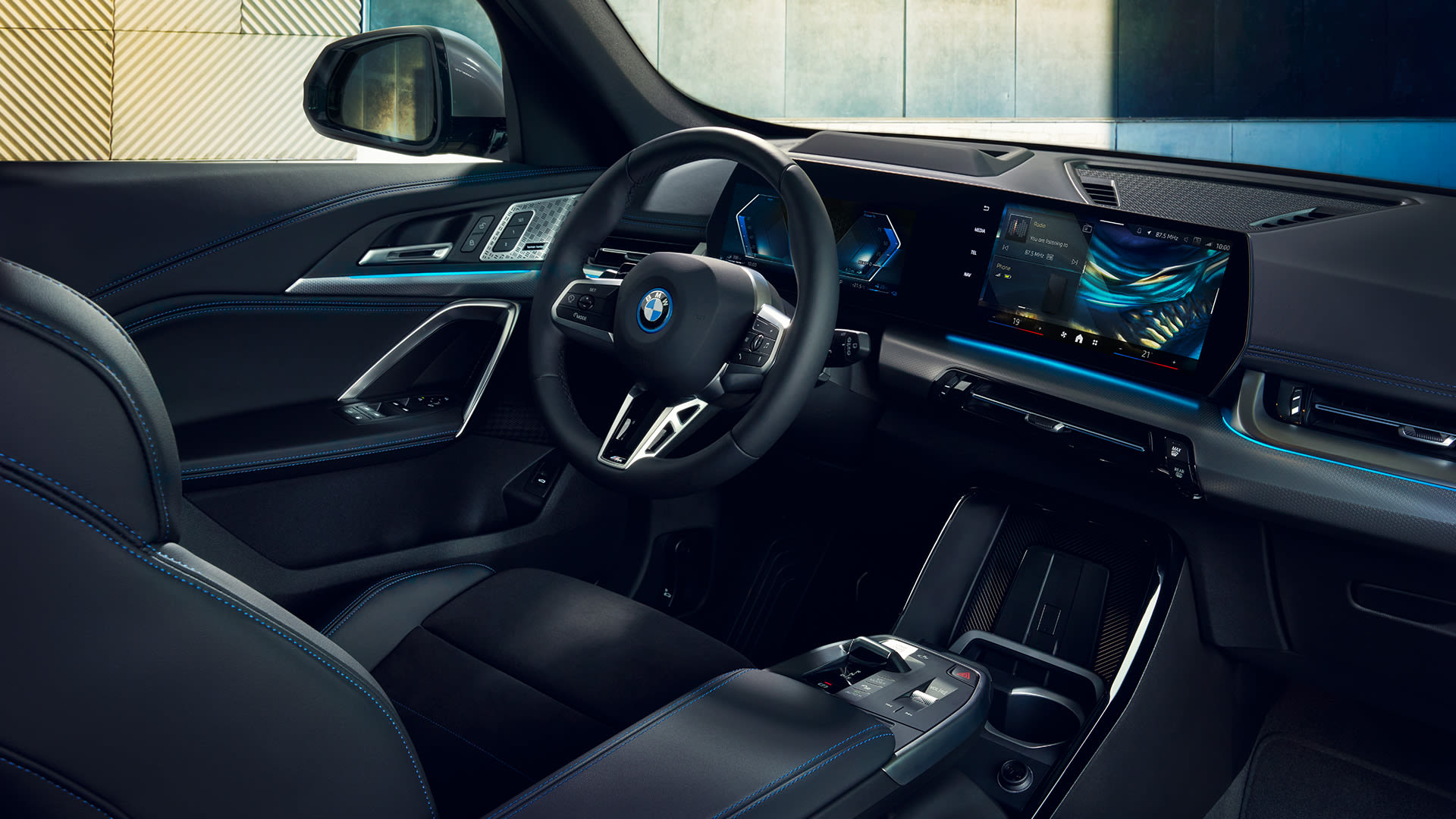 Interior of a modern BMW car showcasing the steering wheel, dashboard with digital displays, and luxurious black leather seats.