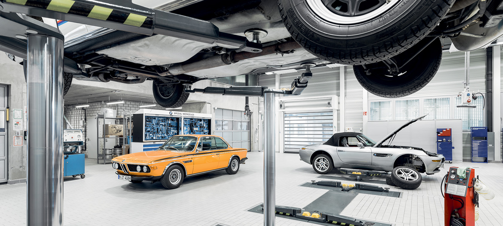 Two BMW Classic cars inside of a professional repair shop