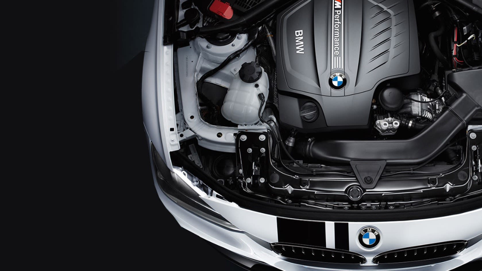 Top view of a BMW car engine with the hood open, showcasing the BMW M Performance engine.
