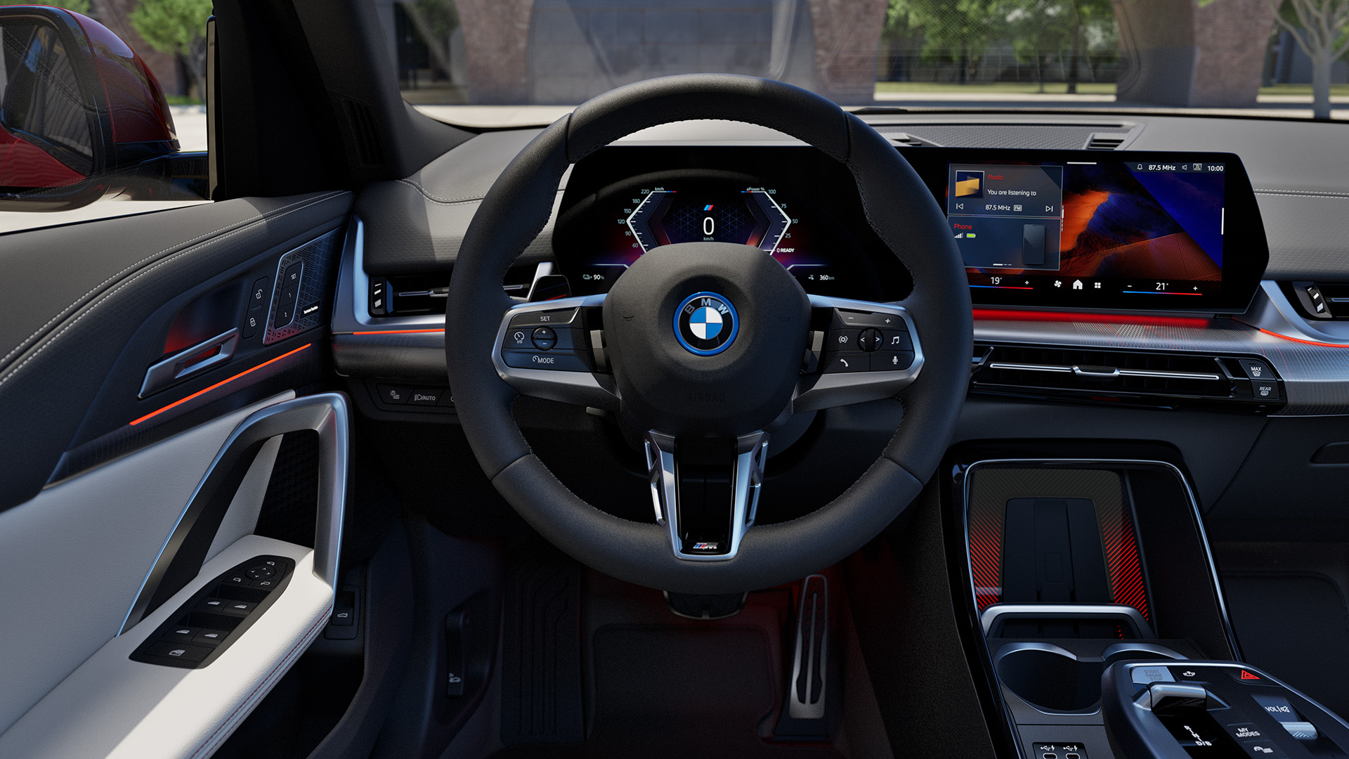Interior view of a modern BMW car showing the steering wheel, dashboard with digital displays, and center console with gear shift.