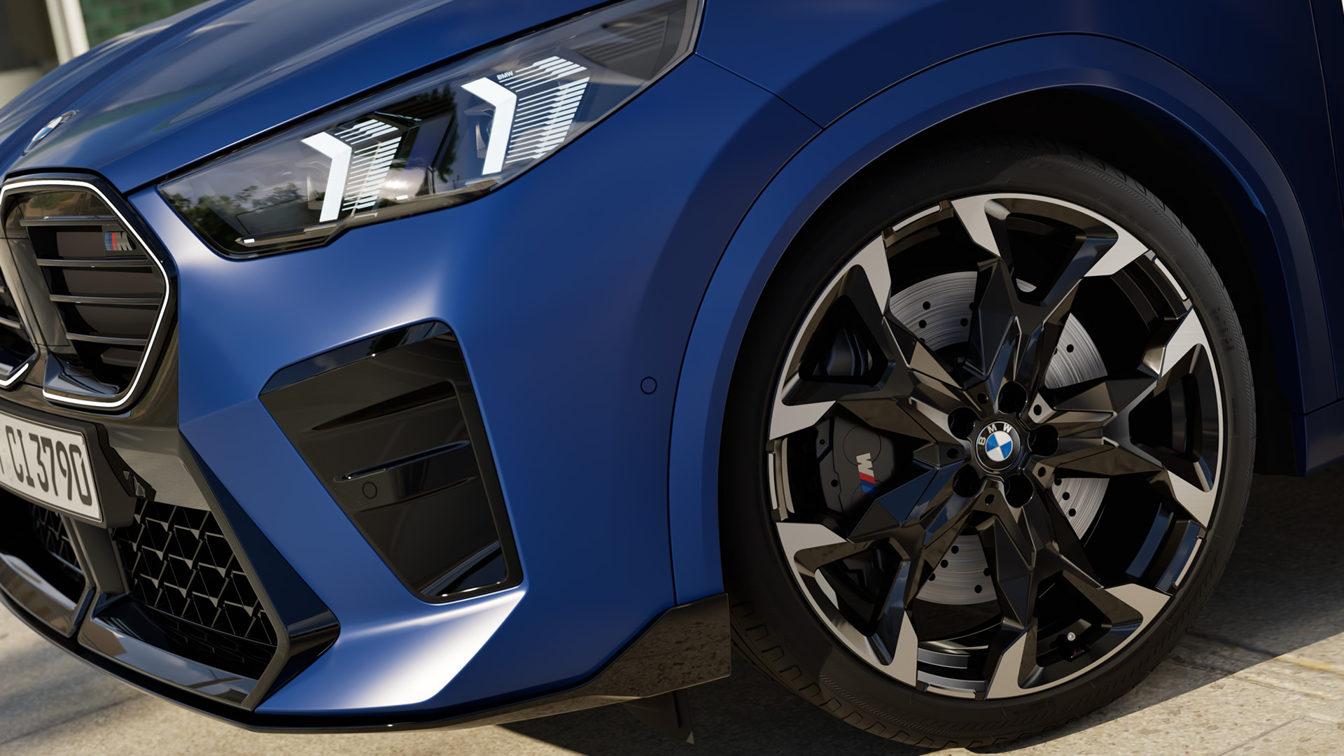Close-up view of the front left side of a blue BMW car, showcasing the headlight, grille, and alloy wheel with the BMW logo.