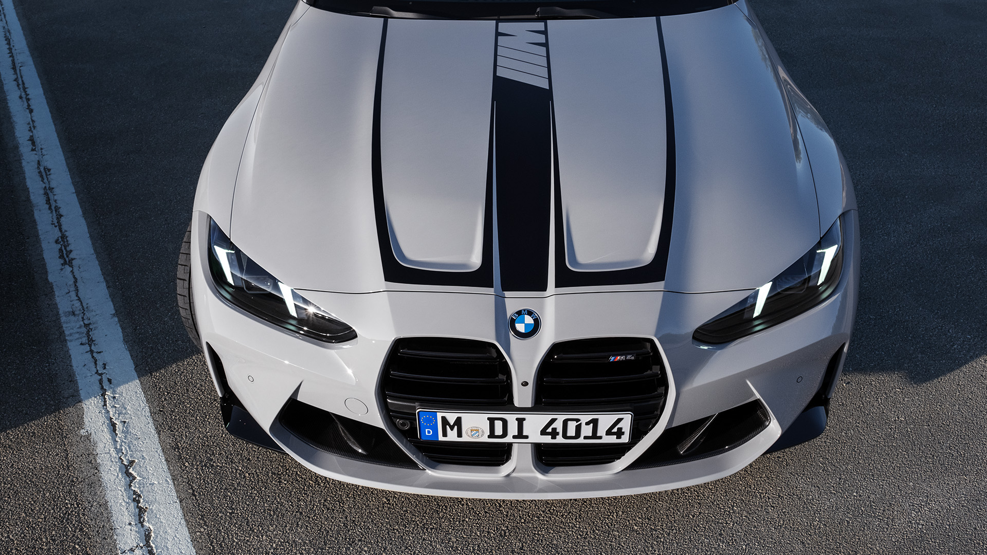 Front view of a white BMW car with black racing stripes.