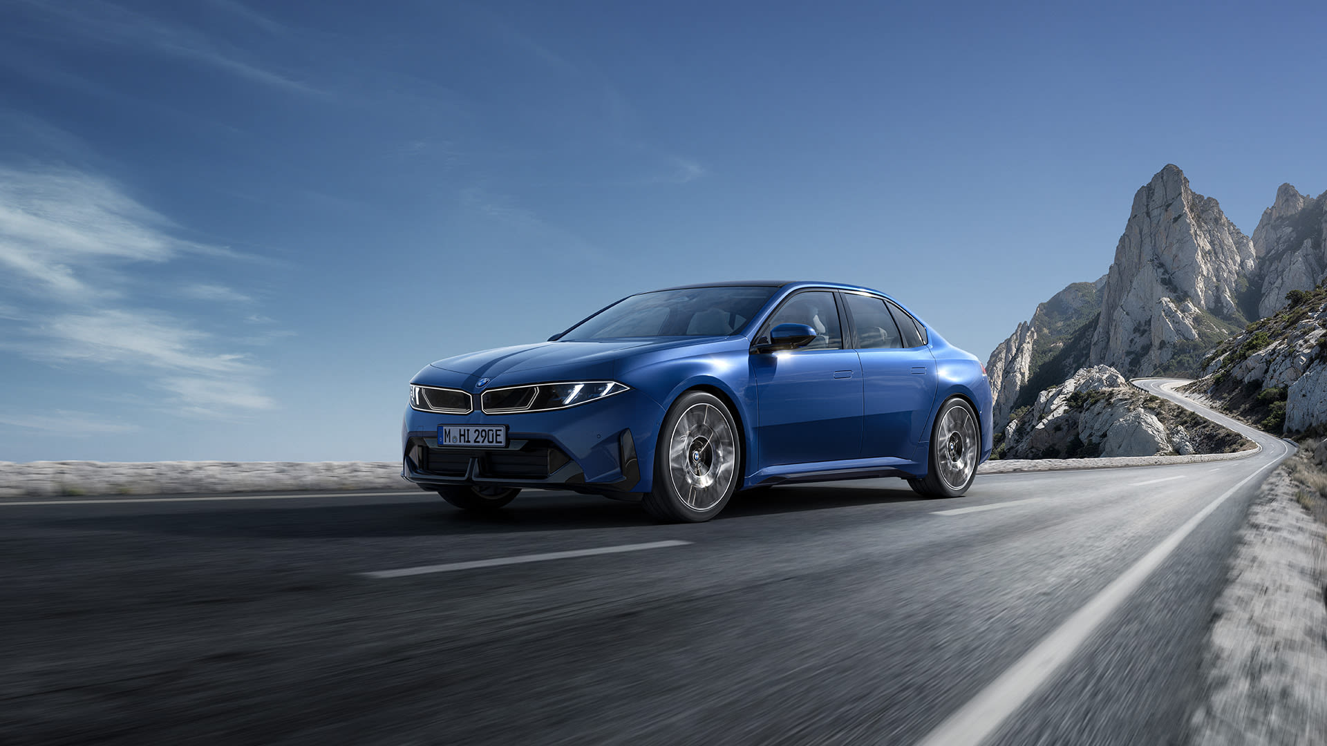 Side view of a blue BMW i3 parked on a raised platform in front of a modern stile building