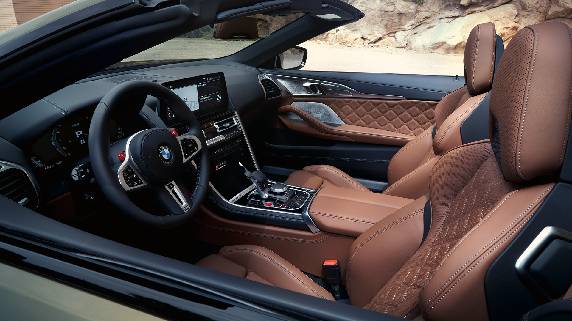 Interior of a luxury BMW convertible featuring brown leather seats, a modern dashboard, and a sleek steering wheel.