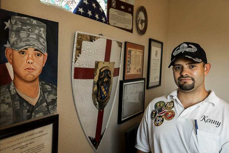 military member stands in front of his military paraphernalia