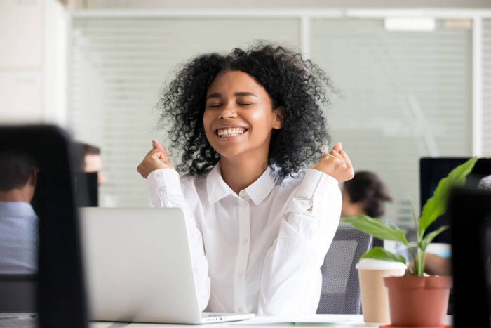 Young woman grinning at her computer