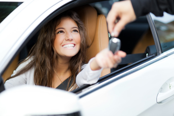 young woman getting the keys to her car