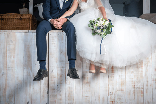 Bride and groom sitting and holding hands