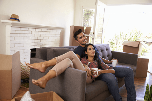 man and woman on couch with moving boxes