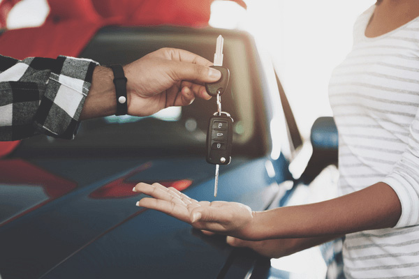 Woman getting the keys to her new car. 
