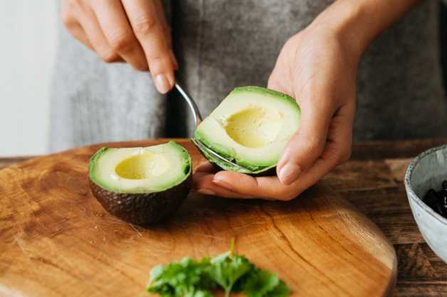 fresh avocado halves being spooned out