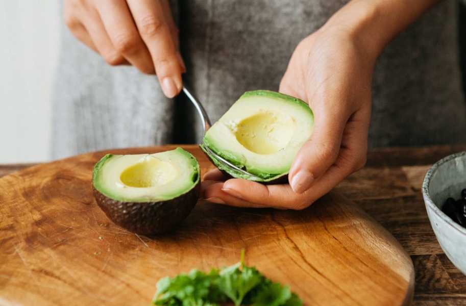 fresh avocado halves being spooned out