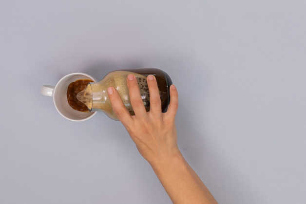 person pouring coffee into a mug