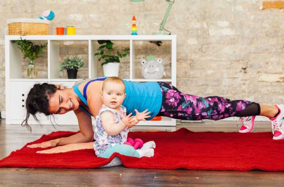 Mother, Ame, doing a plank next to baby