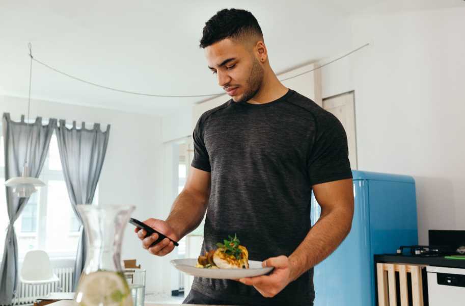 Man holding a plate and a phone