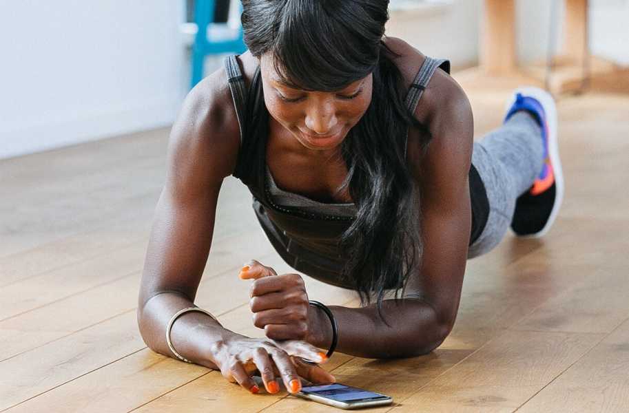 Woman doing a plank and using app