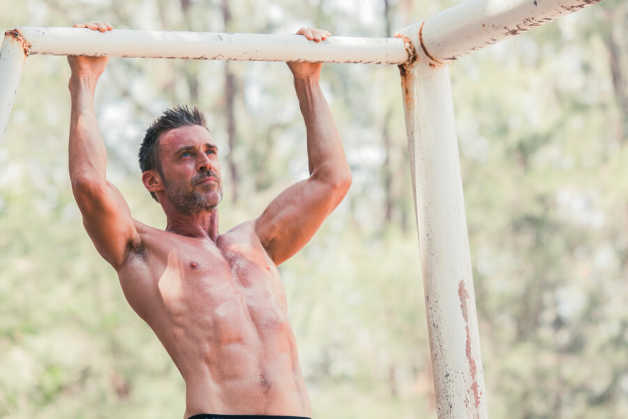 male doing pull ups outside