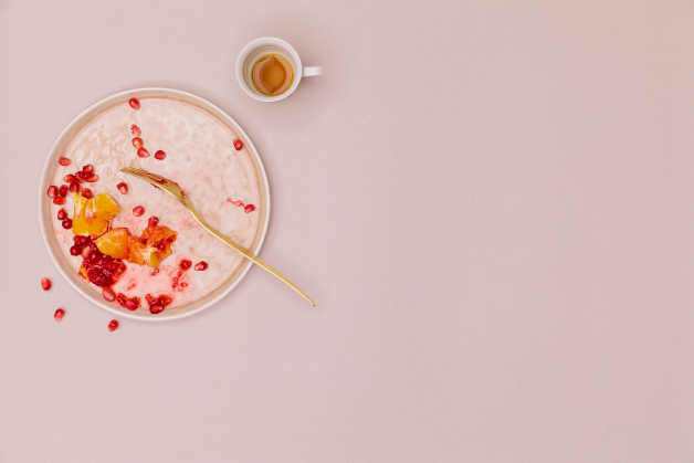 half eaten plate of fruit and empty coffee cup