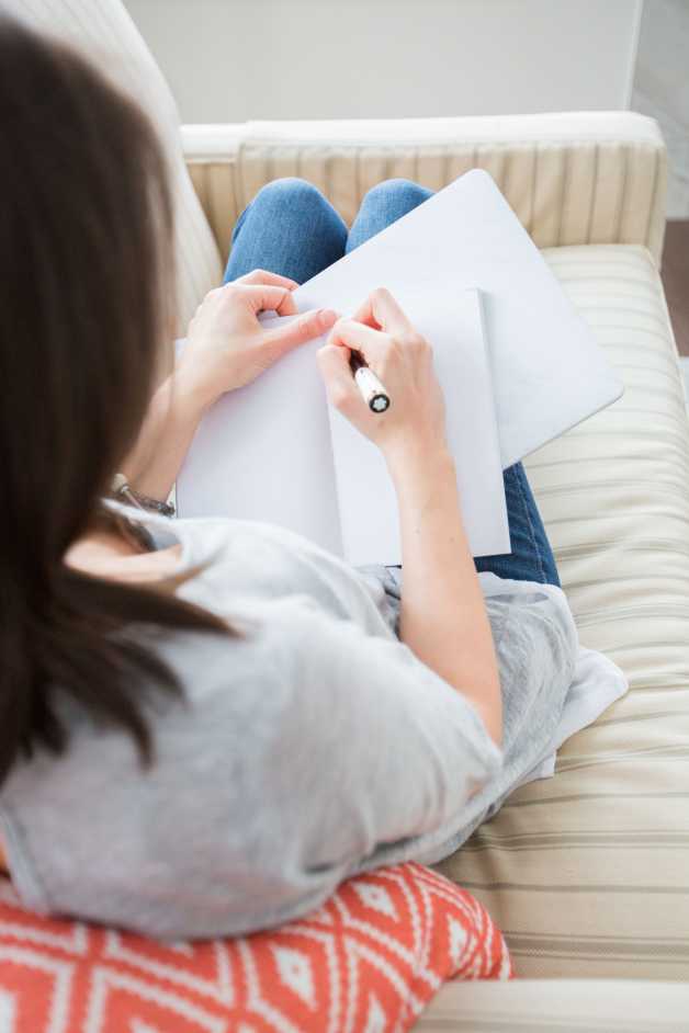 woman on sofa journalling 