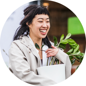 Smiling woman carrying pot plant