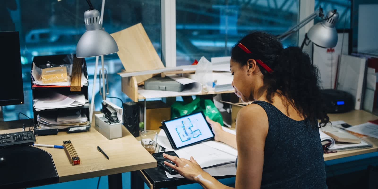 Small business owner working through financial figures in front of warehouse