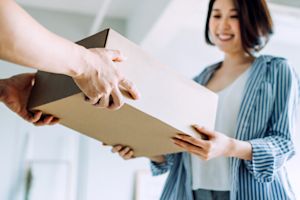 Smiling woman receiving a package delivery at her door