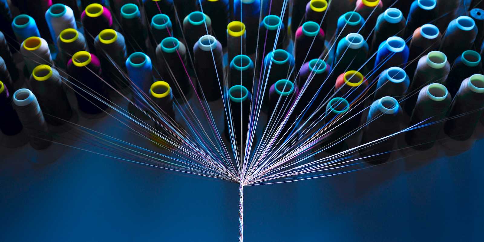 Series of threads being woven into a piece of yarn, symbolizing apparel supply chains