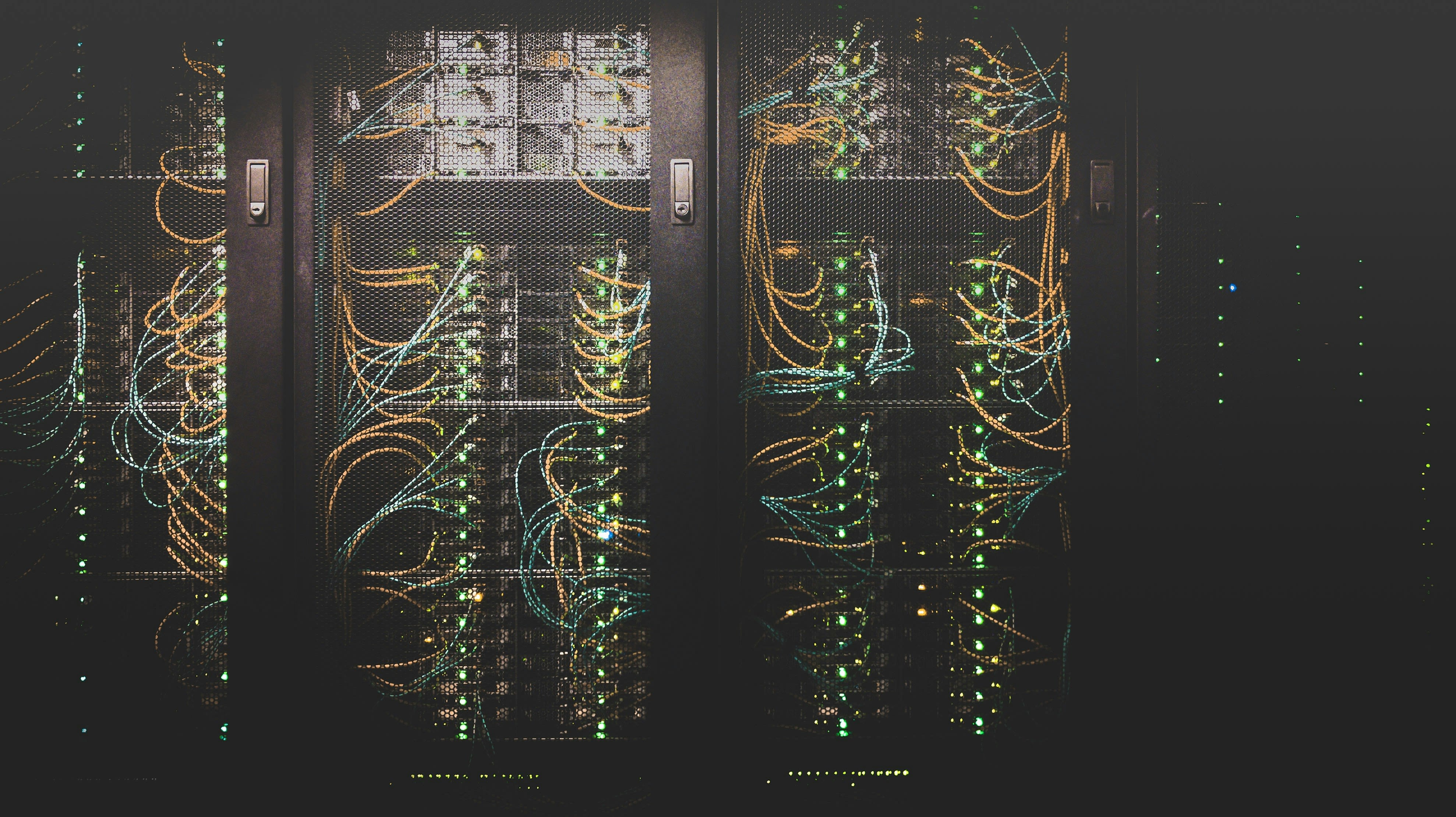 Illuminated server racks with colorful network cabling inside a modern data center