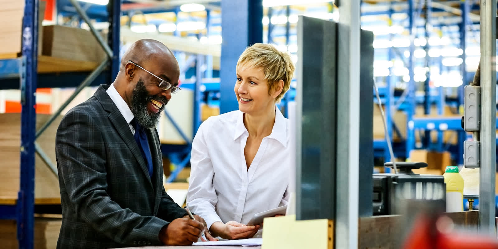 Two people discuss business in a warehouse