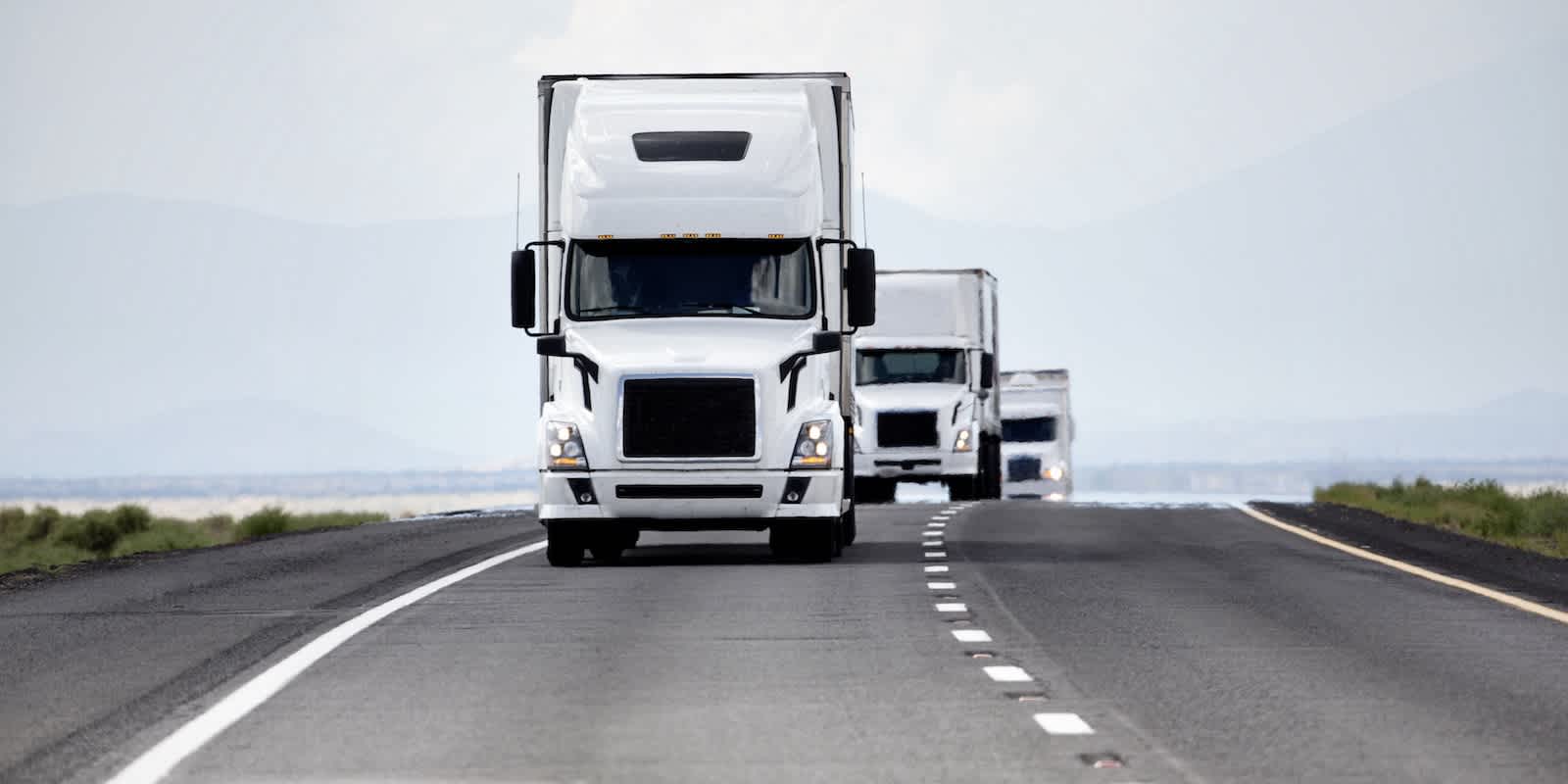 Trucks passing the crest of a hill